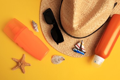 Photo of Flat lay composition with bottles of sunscreen on yellow background