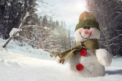 Image of Cute small decorative snowman outdoors on sunny day, space for text