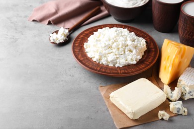 Photo of Clay dishware with fresh dairy products on grey table, space for text