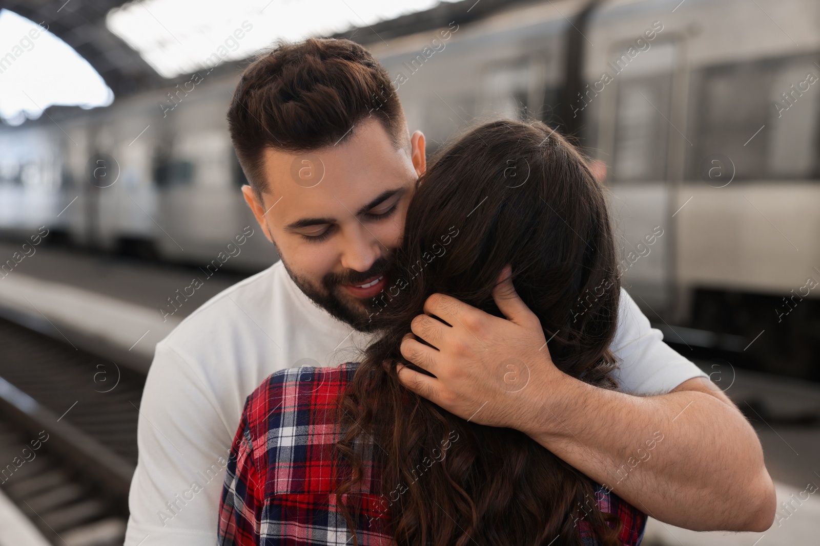 Photo of Long-distance relationship. Couple hugging on platform of railway station