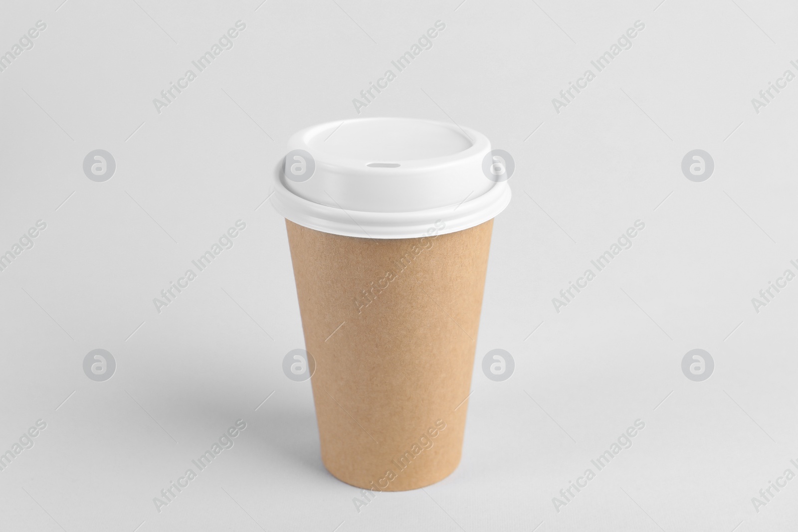 Photo of Paper cup with plastic lid on light background. Coffee to go