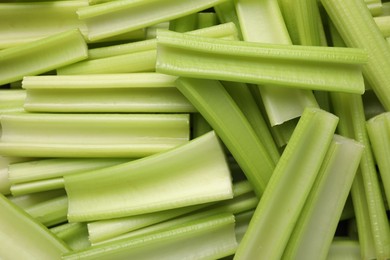 Photo of Fresh green cut celery as background, top view