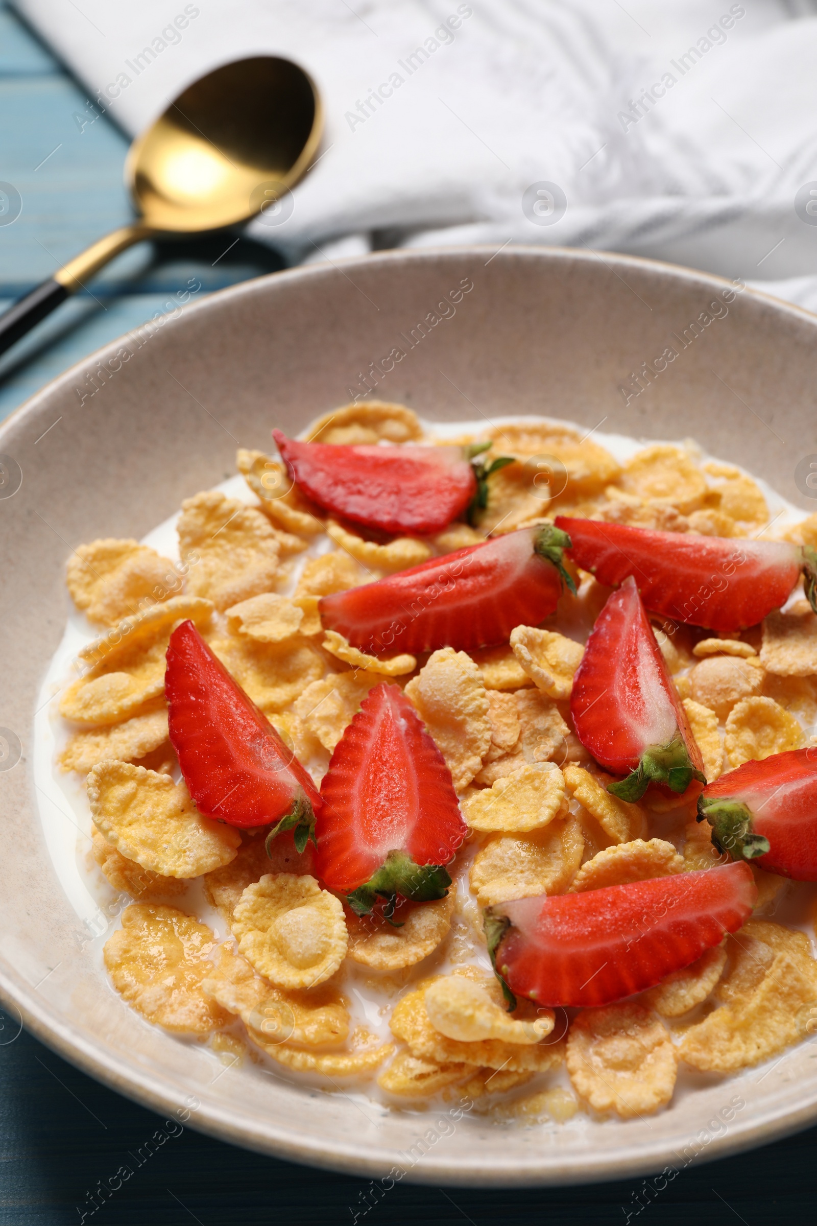 Photo of Delicious crispy cornflakes with milk and fresh strawberries on table, closeup