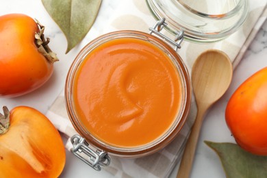 Delicious persimmon jam and fresh fruits on white table