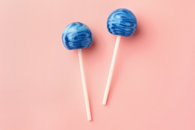 Photo of Tasty lollipops on pink background, flat lay