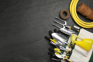 Photo of Flat lay composition with gardening tools on black background, space for text