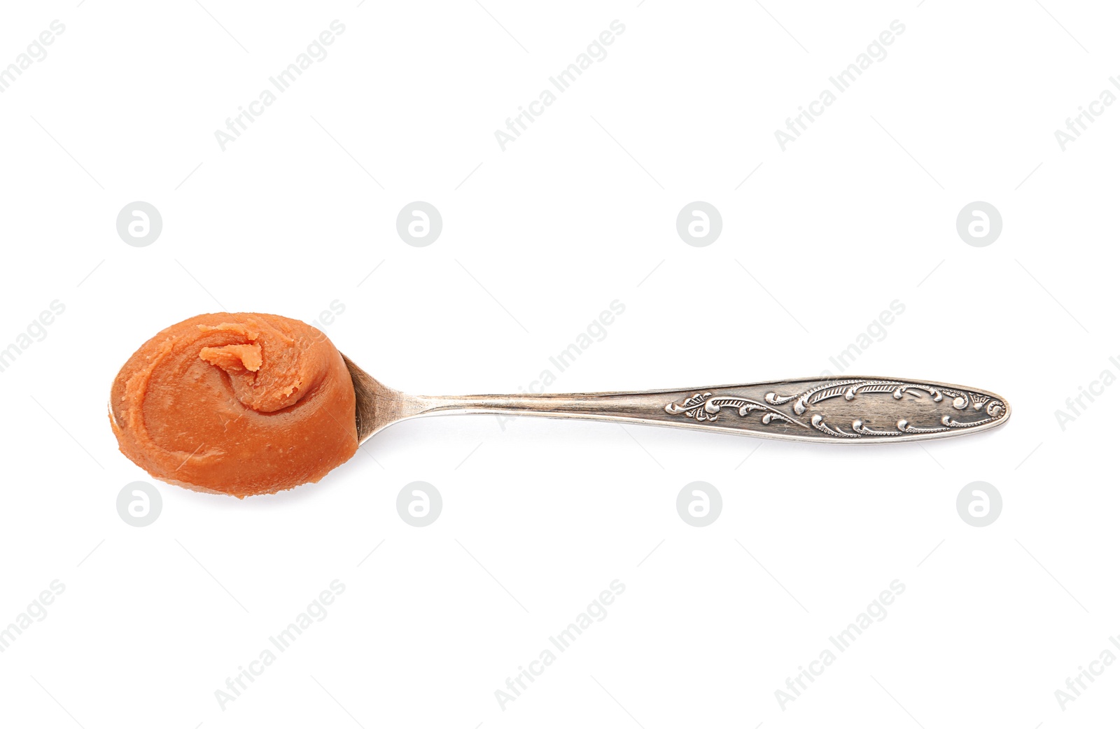 Photo of Spoon with delicious caramel on white background