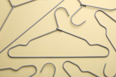 Photo of Hangers on pale yellow background, flat lay