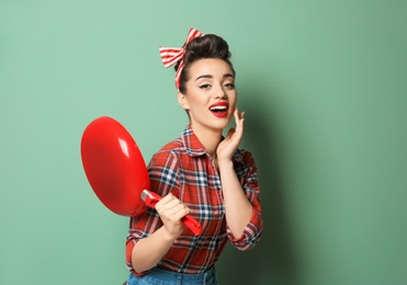 Photo of Funny young housewife with frying pan on color background