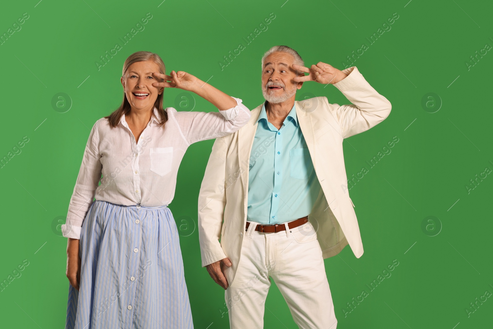 Photo of Senior couple dancing together on green background