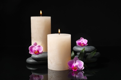 Photo of Composition with candles and spa stones on black background