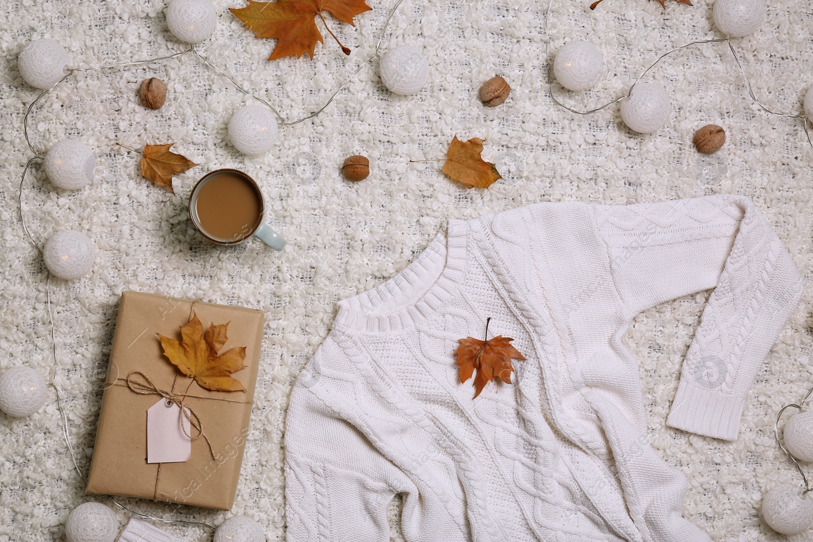 Photo of Flat lay composition with warm sweater on light fabric