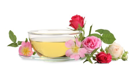 Aromatic herbal tea in glass cup and flowers isolated on white