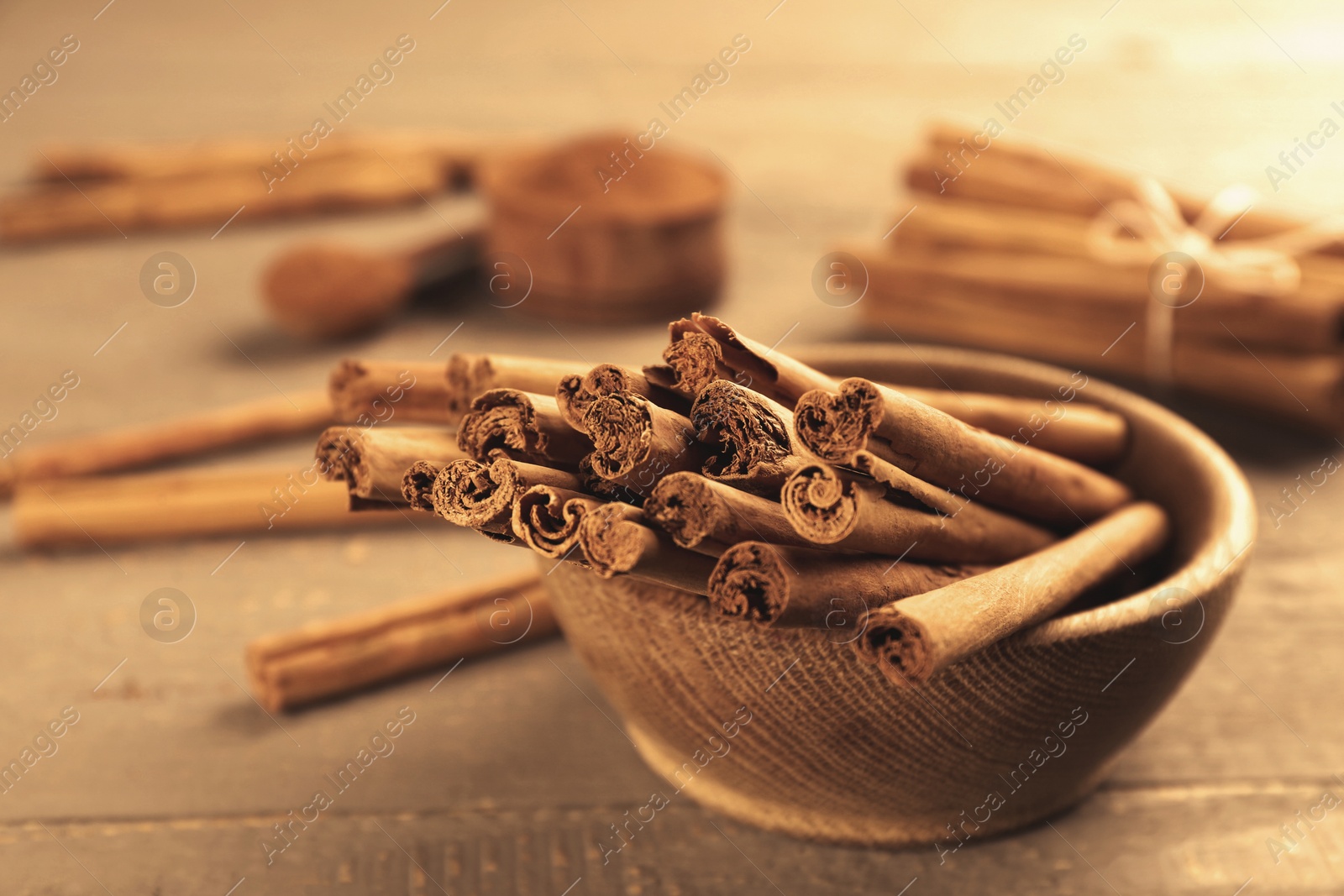 Photo of Aromatic cinnamon sticks on wooden table, closeup