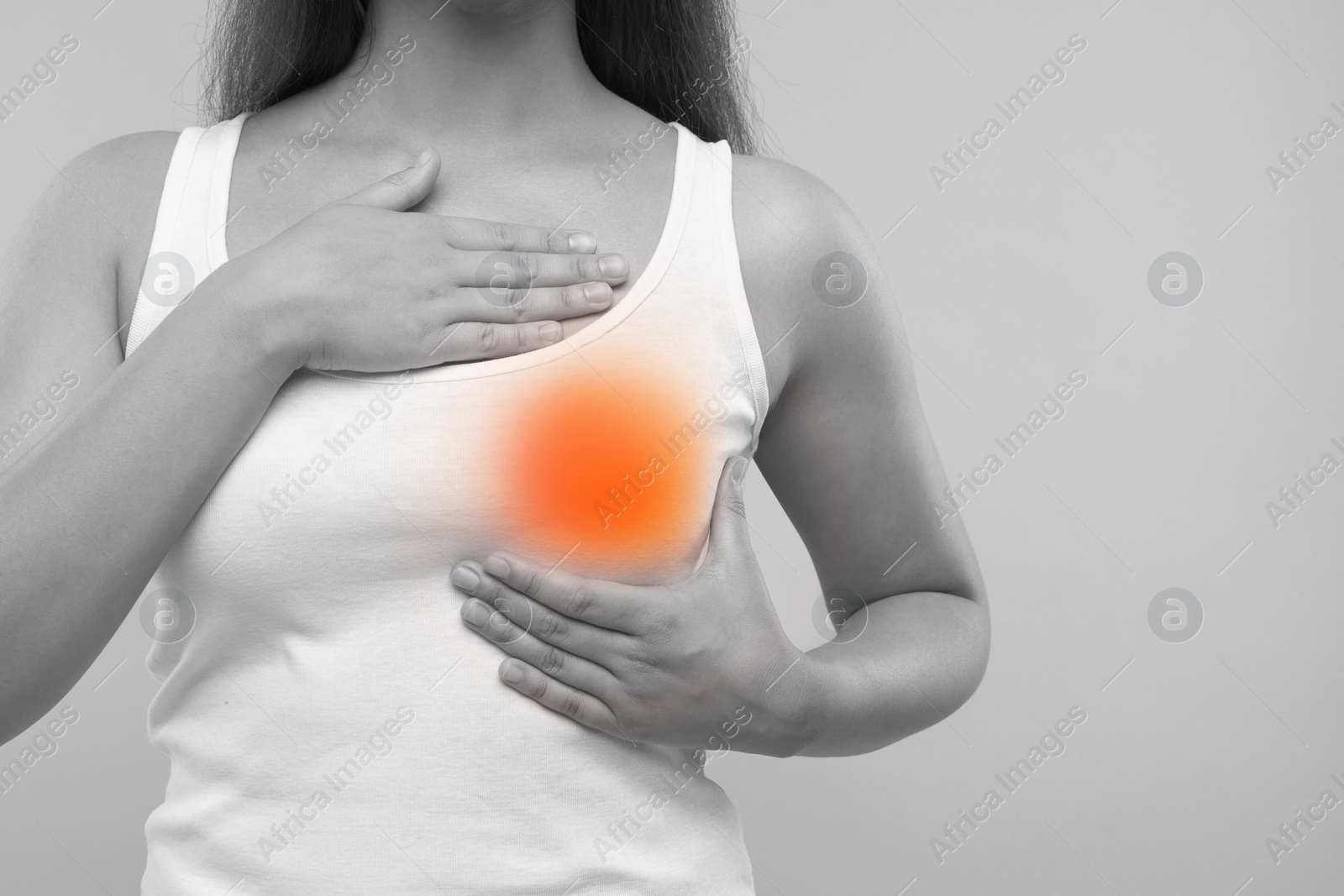 Image of Woman doing breast self-examination on grey background, closeup. Color accent effect