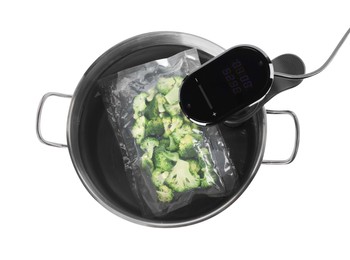 Photo of Thermal immersion circulator and vacuum packed broccoli in pot on white background, top view. Sous vide cooking