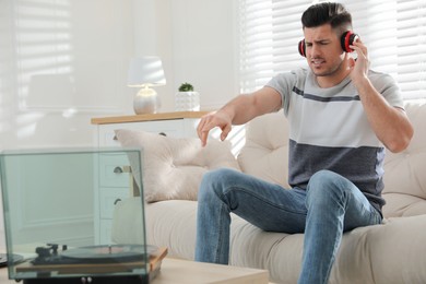 Emotional man listening to music with turntable at home