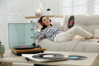 Woman listening to music with turntable in living room