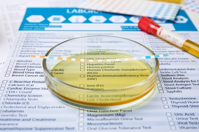 Photo of Petri dish with urine sample for analysis on laboratory test form