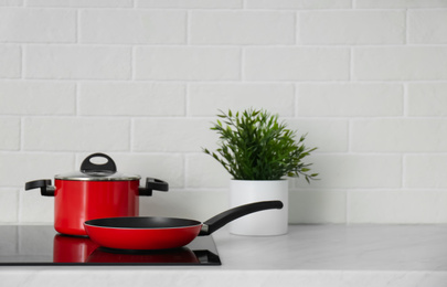 Saucepot and frying pan on induction stove in kitchen