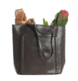 Photo of New leather shopper bag with purchases on white background
