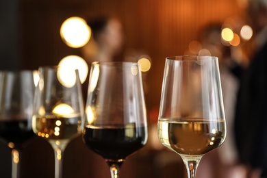 Glasses of different wines against blurred background