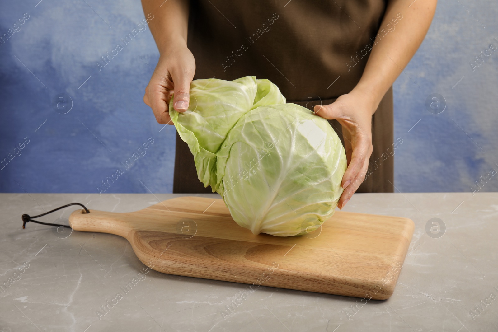 Photo of Woman with ripe cabbage at table, closeup