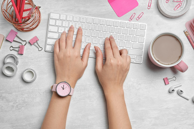 Female designer working with computer at white table, top view