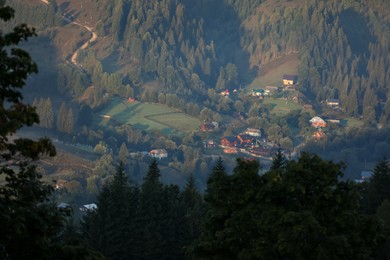 Beautiful view of forest and village in valley on sunny day