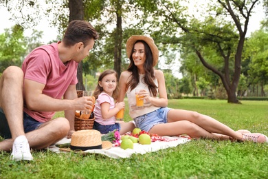 Photo of Happy family having picnic in park on summer day