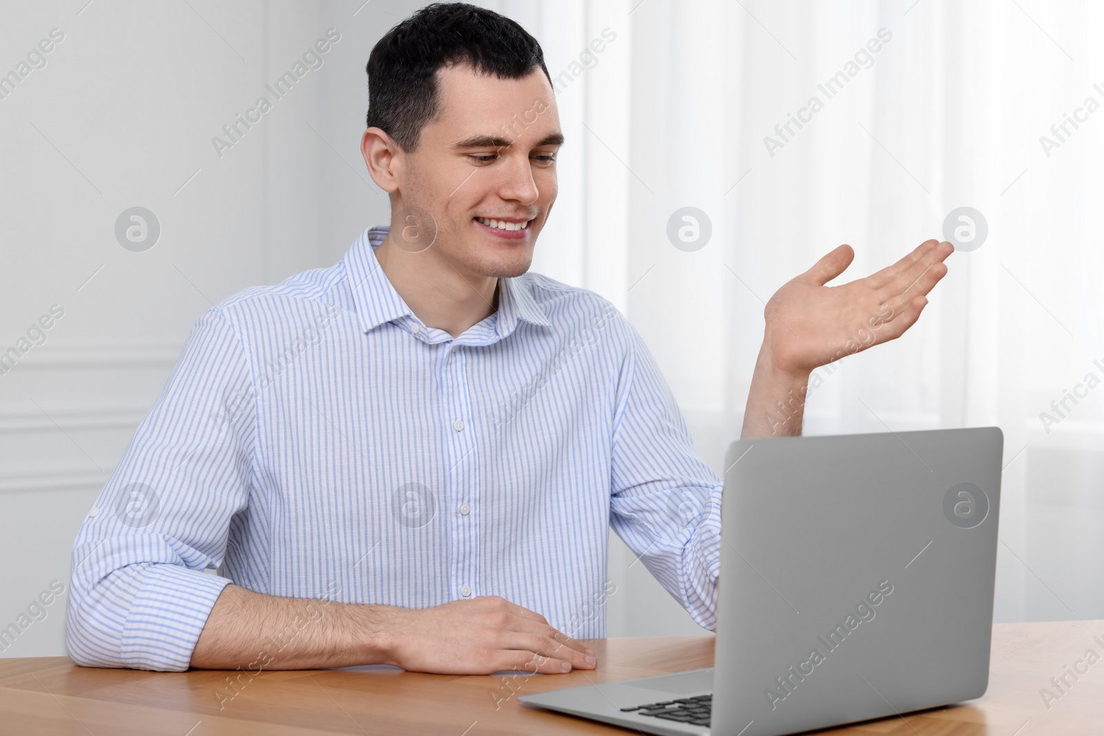 Photo of Man having video chat on laptop indoors