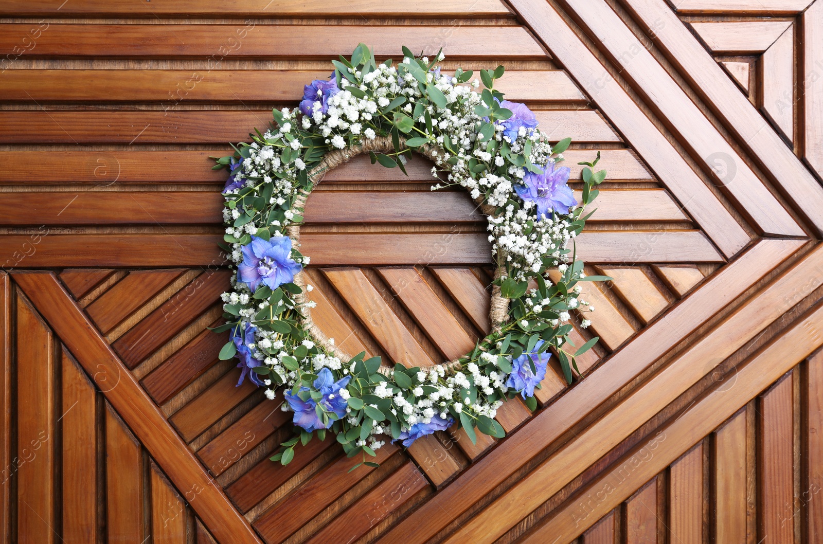 Photo of Beautiful flower wreath on wooden background, top view