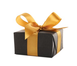 Photo of Black gift box with golden bow on white background