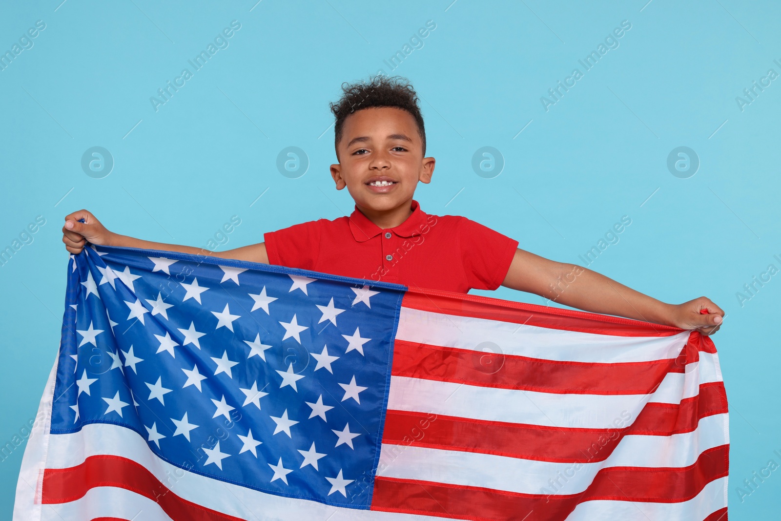 Photo of 4th of July - Independence Day of USA. Happy boy with American flag on light blue background