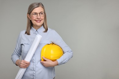 Photo of Architect with hard hat and draft on grey background, space for text