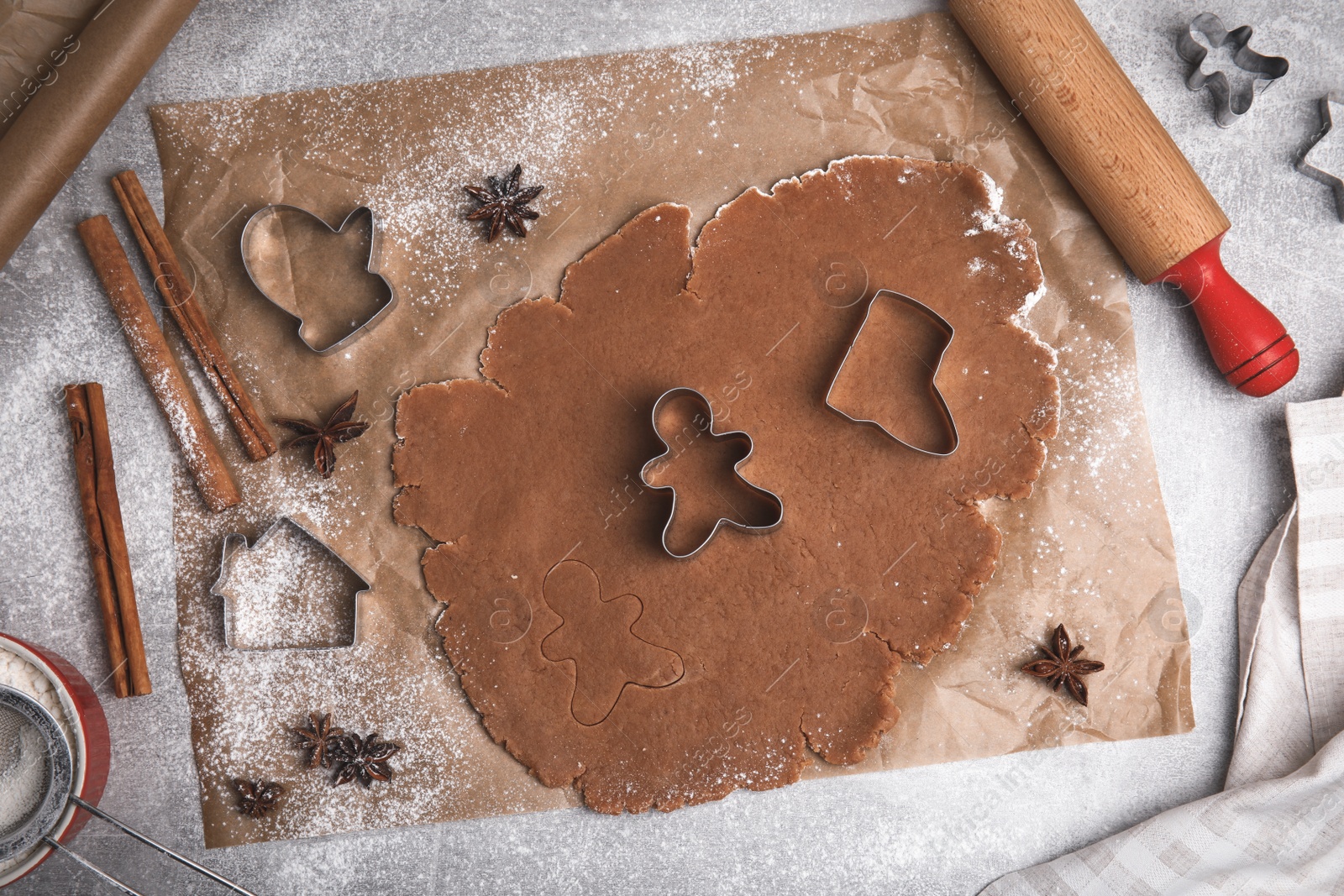 Photo of Making Christmas cookies. Flat lay composition with raw dough and cutters on grey table
