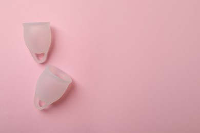 Photo of White menstrual cups on pink background, flat lay. Space for text