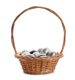 Photo of Basket with painted Easter eggs on white background