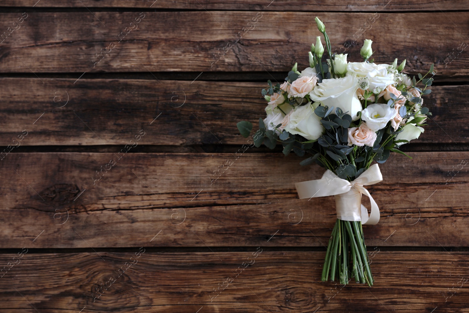 Photo of Beautiful wedding bouquet on wooden table, top view. Space for text