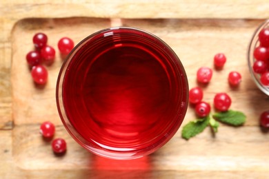 Photo of Tasty refreshing cranberry juice and fresh berries on wooden tray, top view