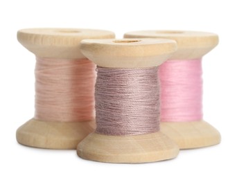 Photo of Different colorful sewing threads on white background, closeup