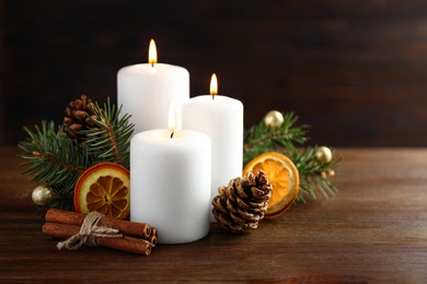 Photo of Beautiful composition with candles and Christmas decor on wooden table