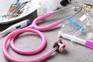 Stethoscope and other medical objects on grey table