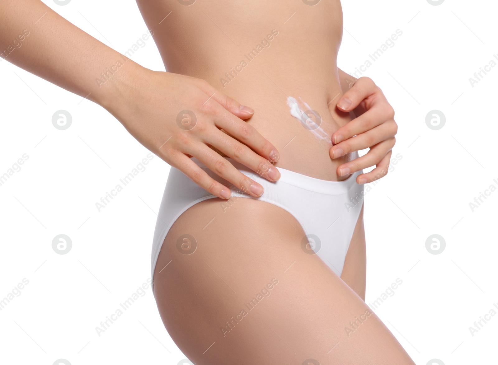 Photo of Young woman with body cream smear on belly against white background, closeup