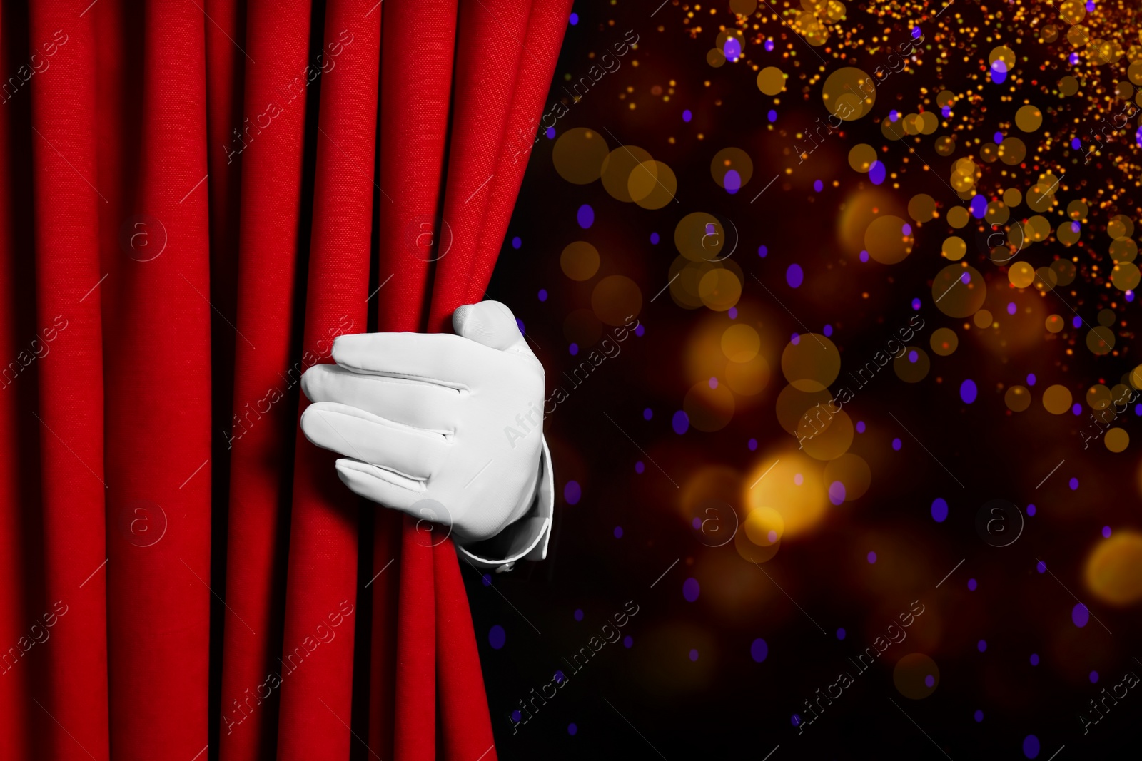 Image of Man opening red front curtain against blurred lights. Bokeh effect 