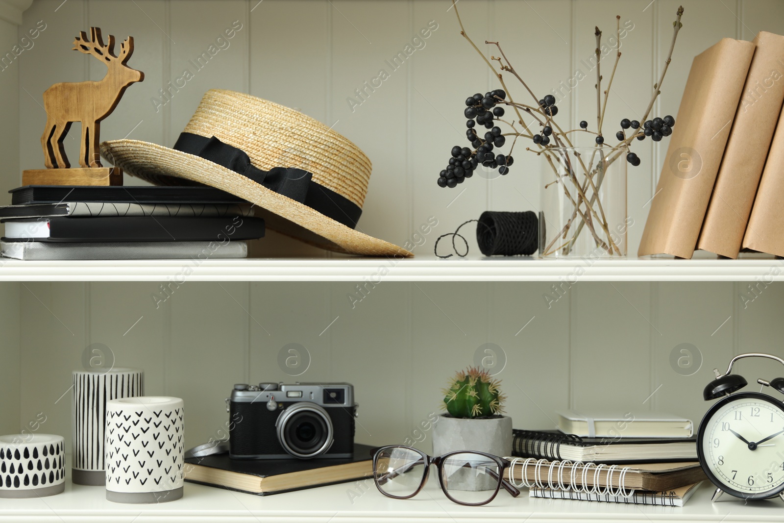 Photo of White shelving unit with straw hat and different decorative elements