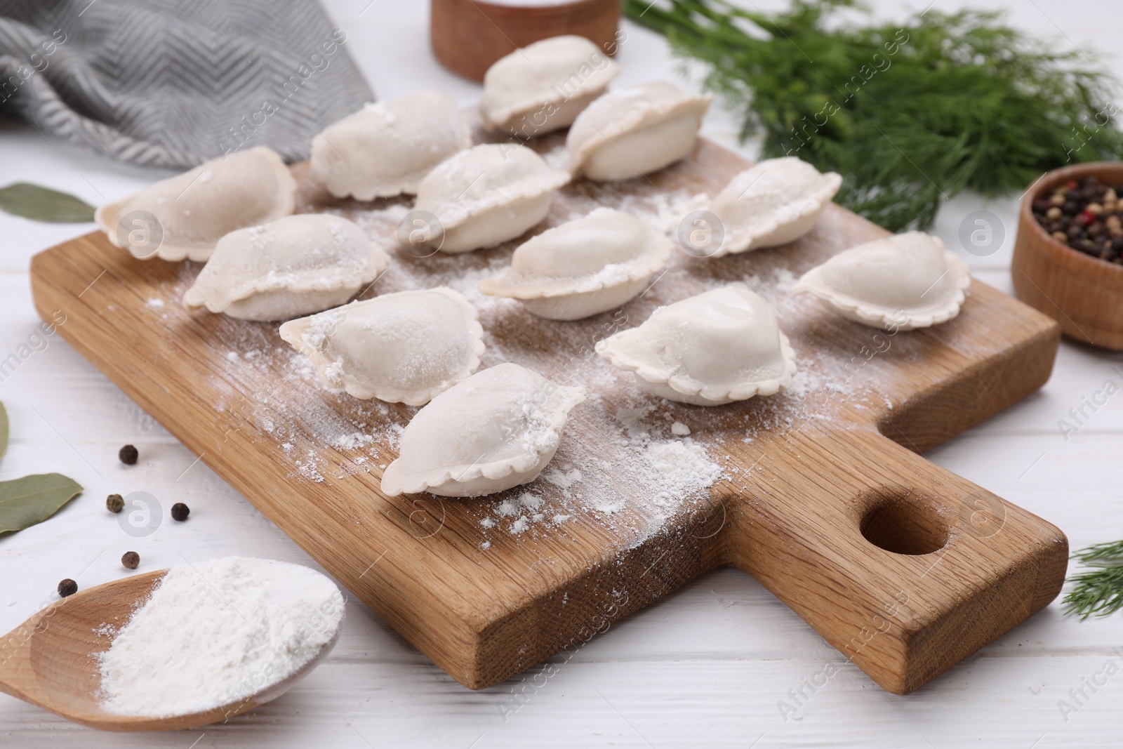 Photo of Raw dumplings (varenyky) on white wooden table, closeup
