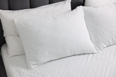 Photo of Soft white pillows and bedsheet on bed