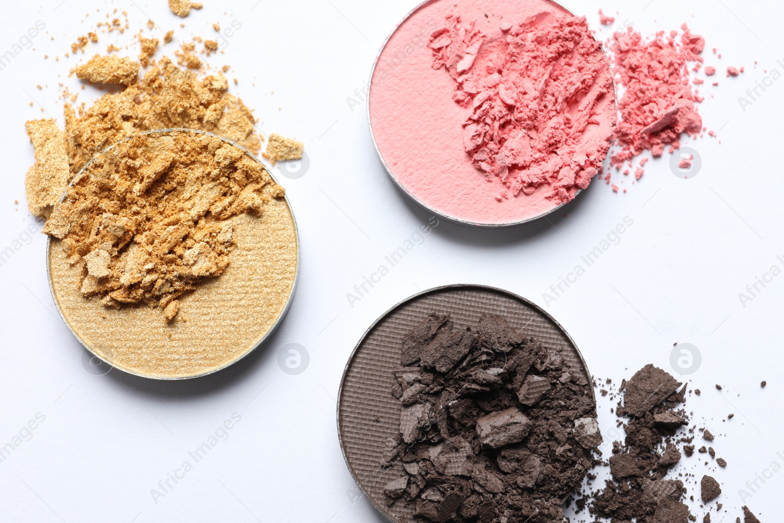 Photo of Different crushed eye shadows on white background, flat lay. Professional makeup product