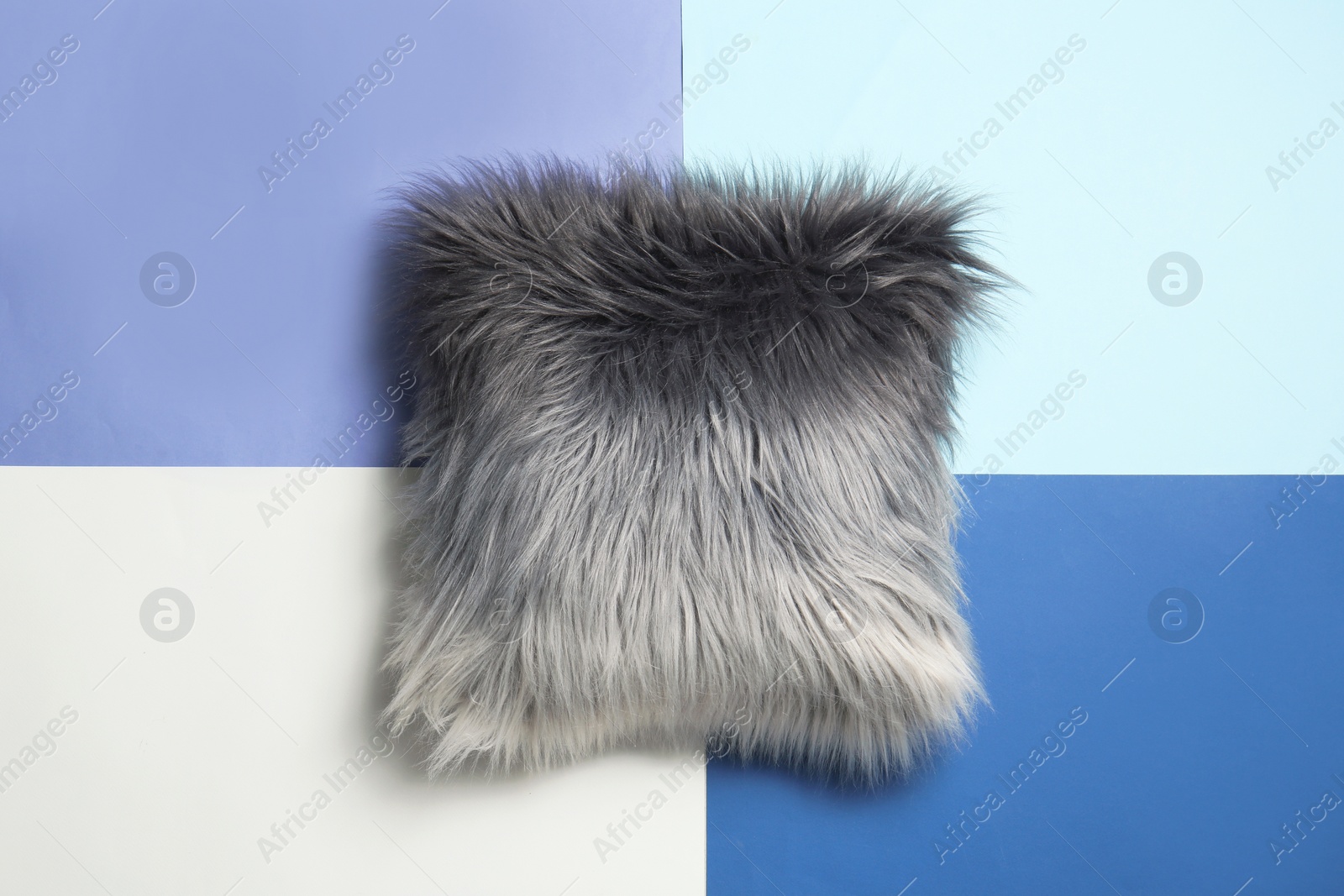 Photo of Fuzzy decorative pillow on color background, top view